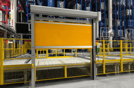 Yellow high-speed door installed in an automated warehouse conveyor area