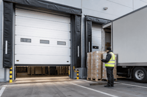 High speed sectional door in a logistics facility with a worker loading pallets.